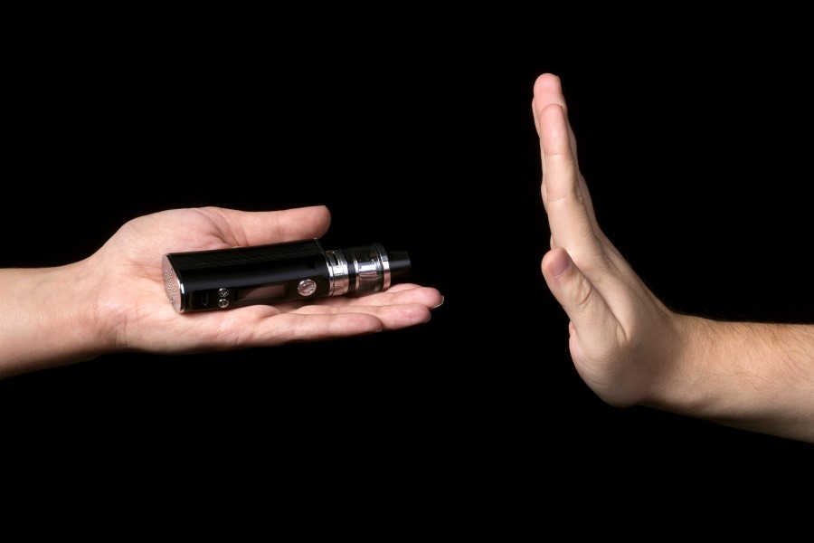 hand gesturing to stop quitting tobacco by not taking an e-cigarette