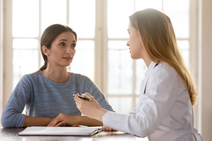 Woman with a genetic counselor at a desk talking about cancer genetic testing