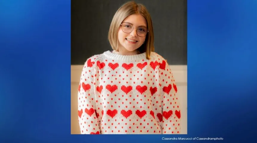 Adelaide Greenwald, looking at the camera, wearing a white sweater with a red heart pattern.