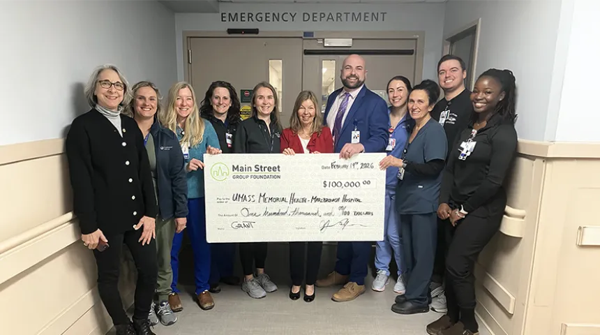 A group of caregivers at the Marlborough Campus hold up a large-size check from Community Bank in the amount of $100,000..