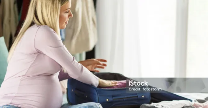 An expecting mother packs a bag for the maternity ward.