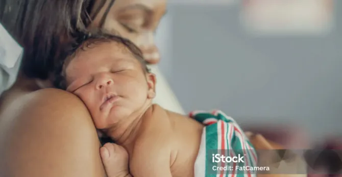 Young mom hugging her newborn baby after delivery.