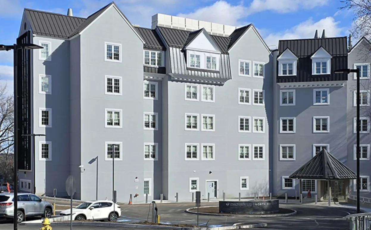 The front entrance of the UMass Memorial Medical Center North Pavilion, a gray building with a dark gray roof.