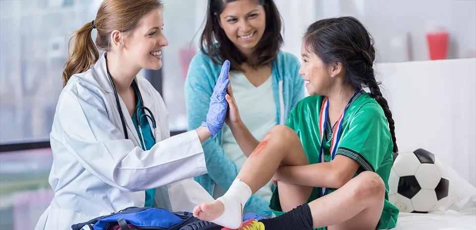 A little girl high-fives the doctor in Urgent Care having had her ankle bandaged and a bad scrape treated.
