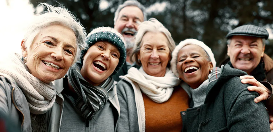 A group of seven people wearing fall clothing looks at the camera, smiling.