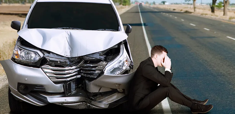 man getting in car crash and on the side of the road upset