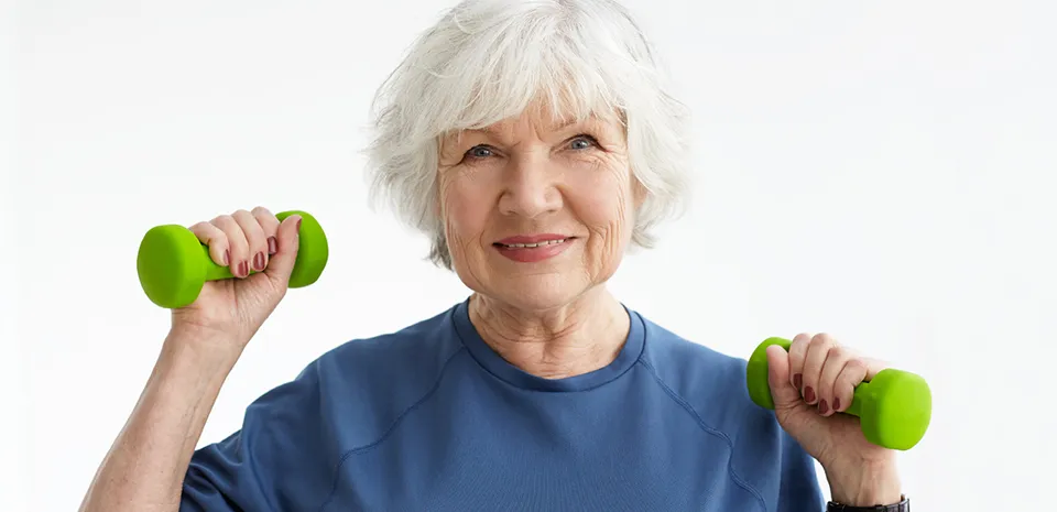 elderly woman lifting dumb bells and exercising