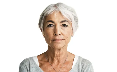 An older woman is shown straight on against a white background.