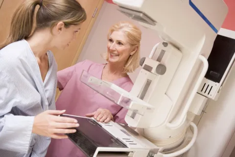 woman having mammogram talking with technician about the Tyrer Cuzick breast cancer screening tool