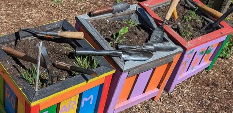 Planters display the gardening tools transformed by the Guns 2 Gardens organization.