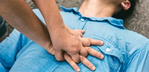 person giving CPR chest compressions