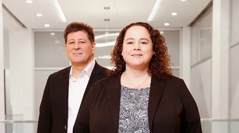 Dr. Eric Alper, Senior Vice President, System Chief Quality Officer and Chief Clinical Informatics Officer and Erica Smith, Erica Smith, Chief Nursing Informatics Officer and Associate Vice President of Clinical Informatics stand together in the office space of UMass Memorial Health.