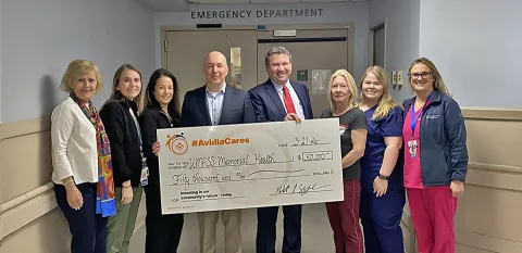A group of caregivers and Rob Cozonne, President and CEO of Avidea Bank pose holding an extra large-size check representing the $50,000 donation to the expansion of the Marlborough Campus ED..