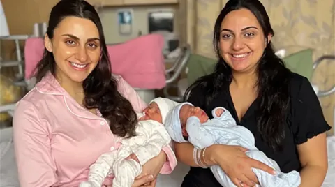 Dalina Hanna and her older sister, Jouliana Fazah, hold their newborn babies for a photo of the four.