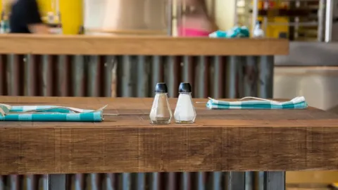 A salt and pepper shaker are sitting on a table.