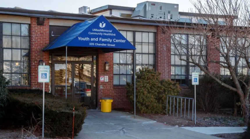 A blue awning is over the entrance of a red brick building, the Community Healthlink, Inc. - Youth and Family Behavioral Health Services at 355 Chandler Street in Worcester.