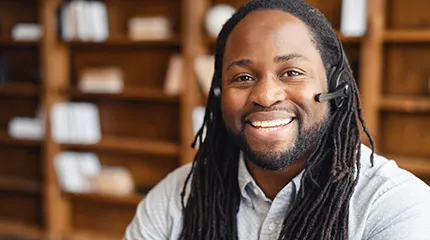 Man wearing phone headset smiles at camera
