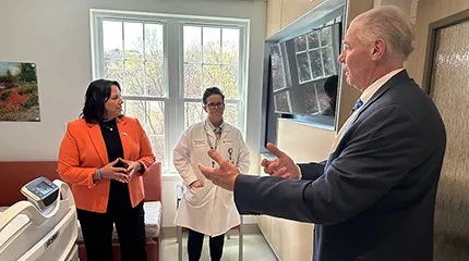Dr. Eric Dickson, President and CEO of UMass Memorial Health speaks to others in a North Pavilion patient room.