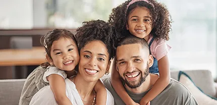 A family of four smiling at the camera.