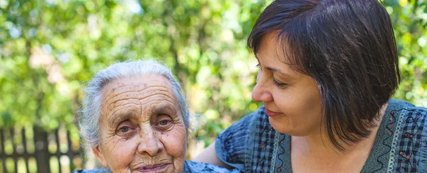daughter looking and holding elderly mother